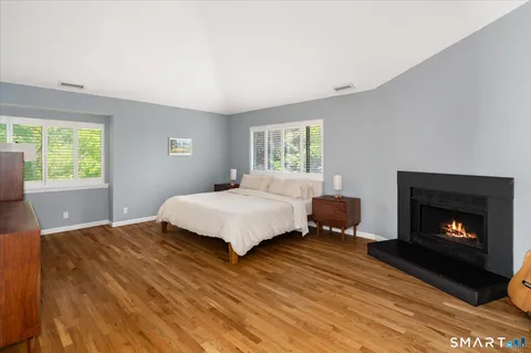 a bedroom with a bed a fireplace and window