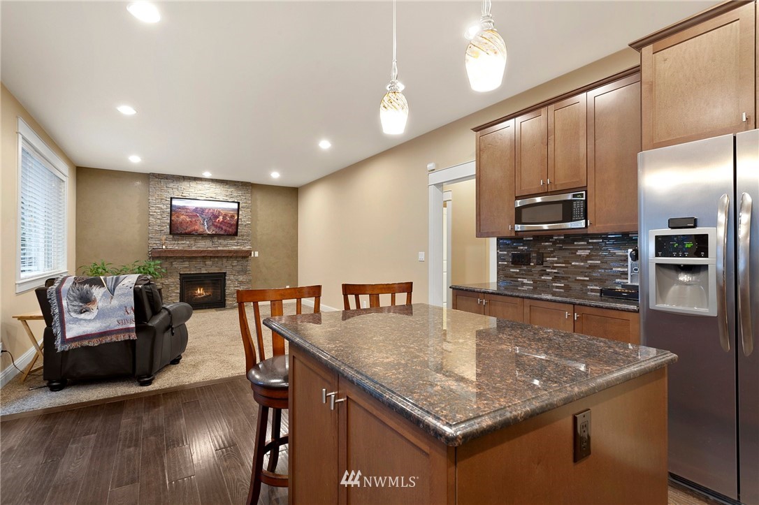 32233 Military Road South Federal Way, WA 98001 - Photo 12 of 28 a kitchen with stainless steel appliances granite countertop a sink dishwasher and a refrigerator with wooden floor