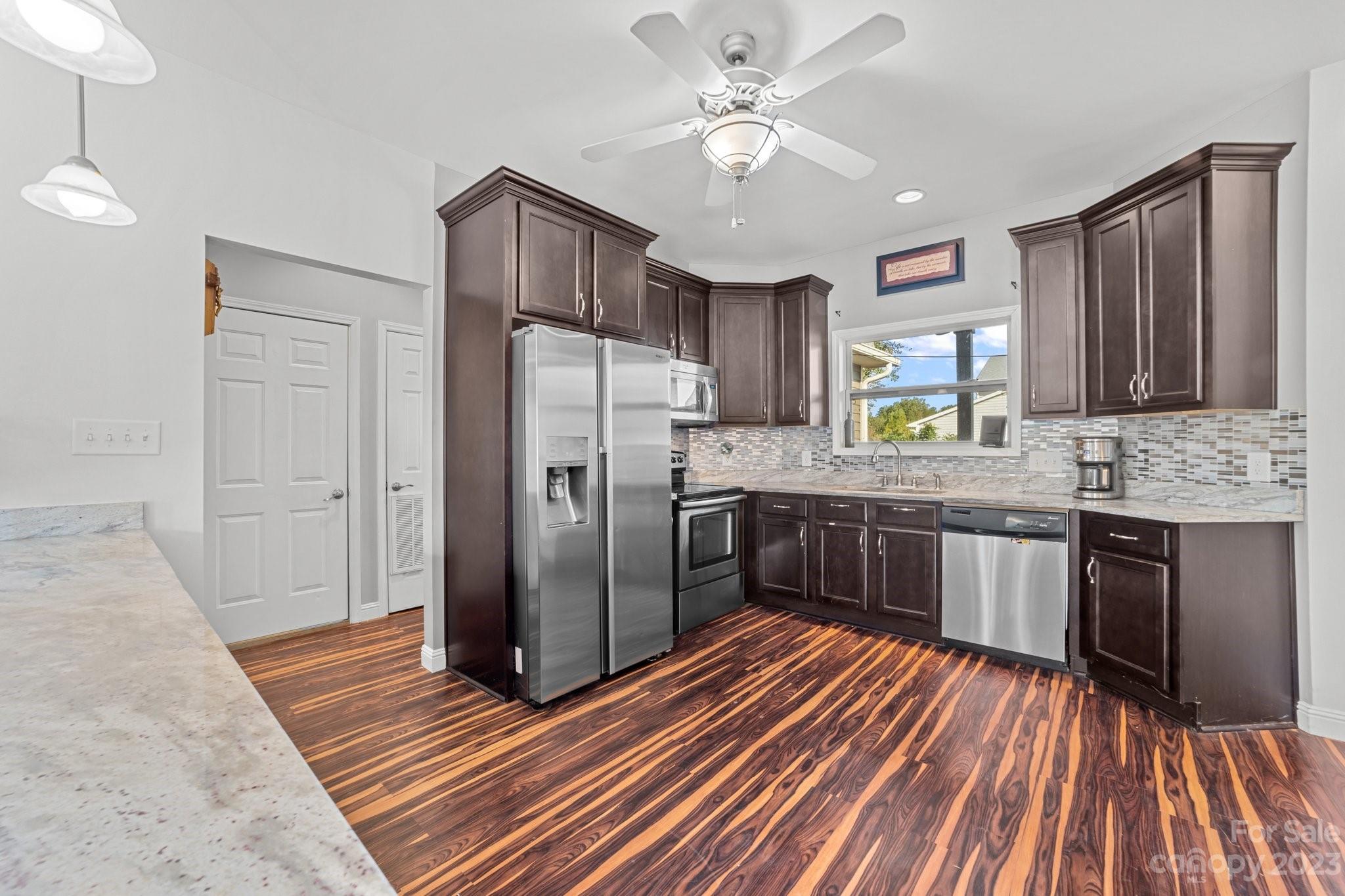 105 Vista Drive Davidson, NC 28036 - Photo 13 of 29 a kitchen with stainless steel appliances granite countertop a refrigerator a sink dishwasher a stove with wooden cabinets and floor