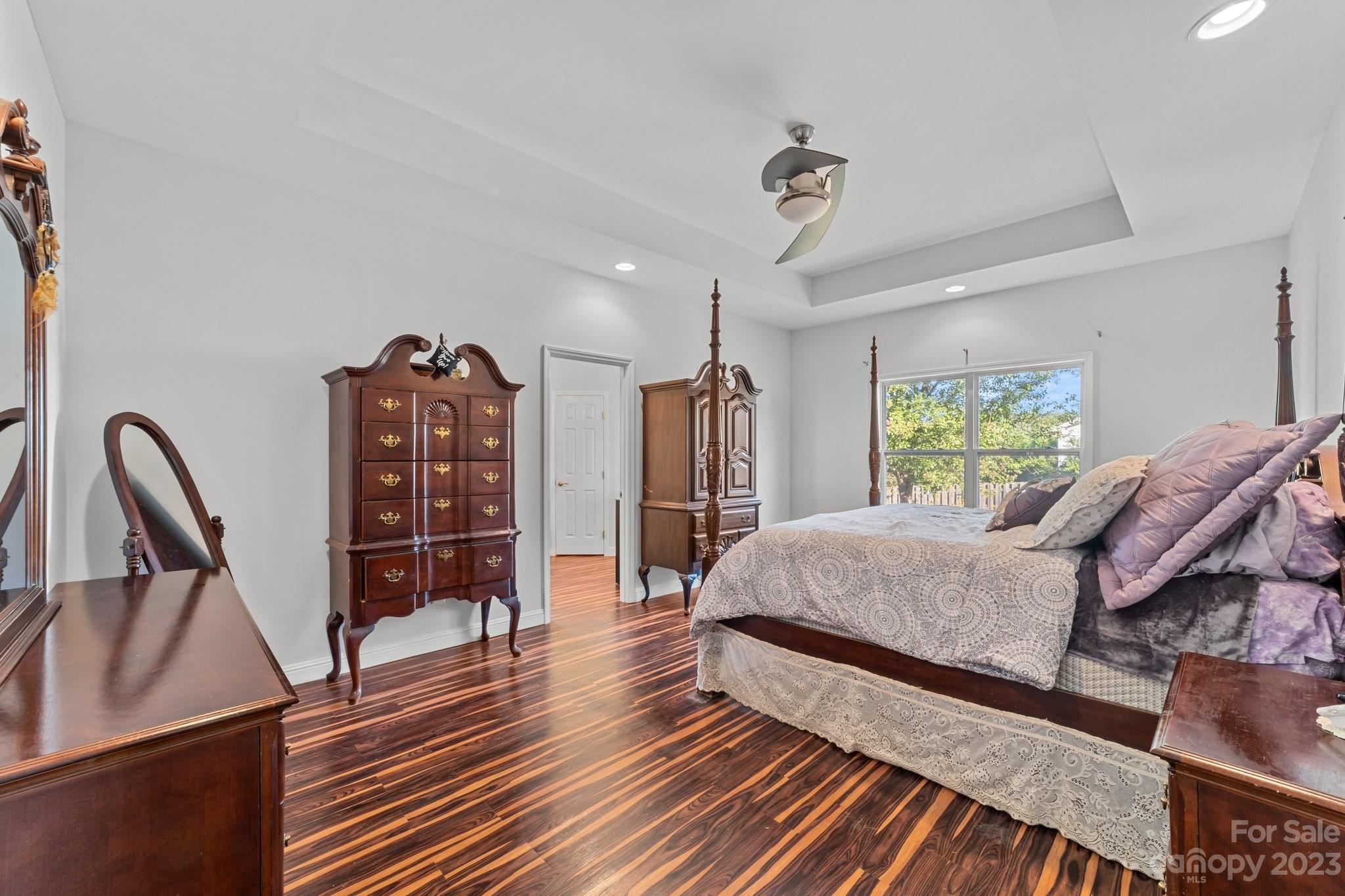 105 Vista Drive Davidson, NC 28036 - Photo 16 of 29 a spacious bedroom with a bed a dresser and wooden floor