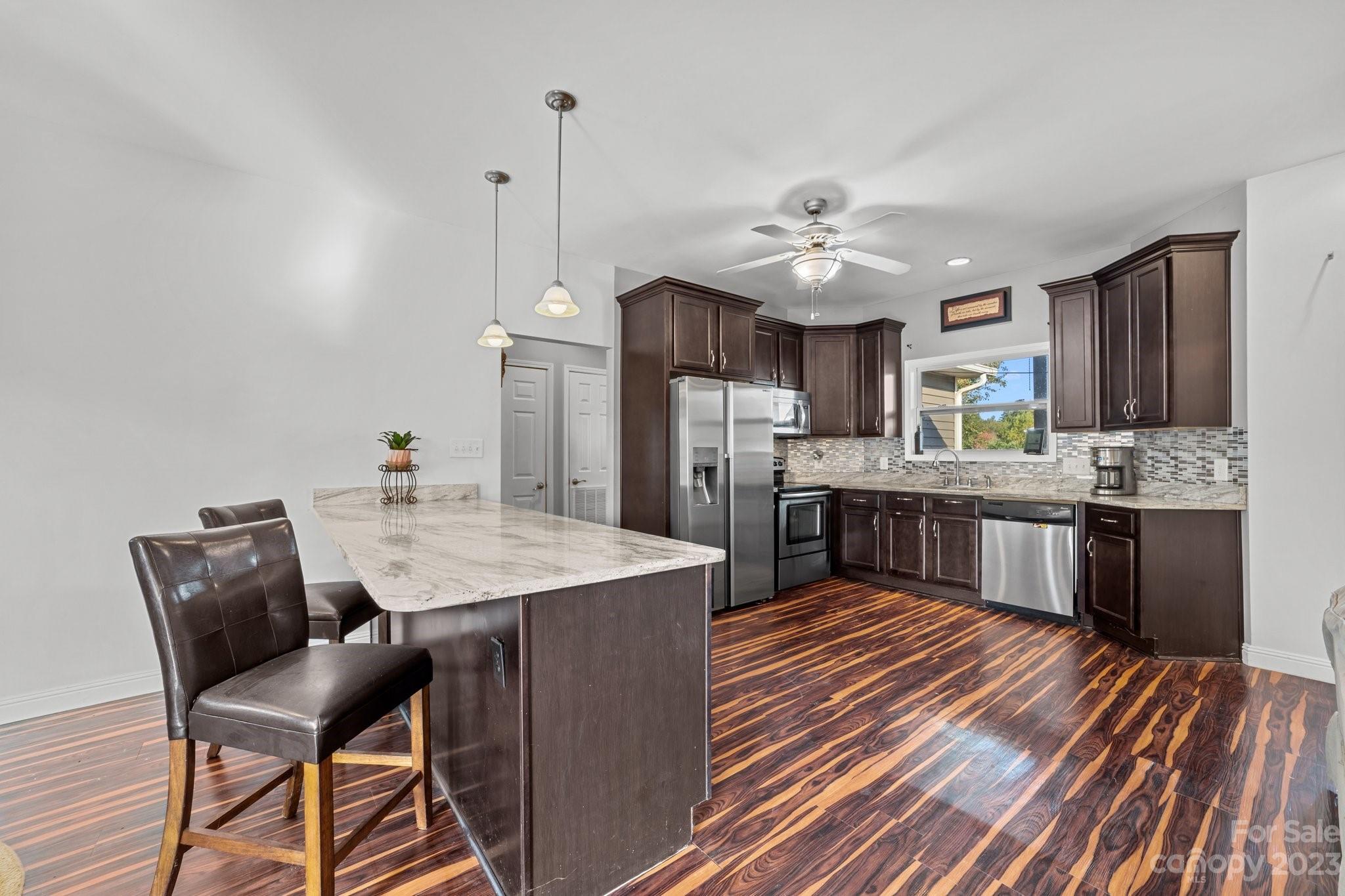 105 Vista Drive Davidson, NC 28036 - Photo 10 of 29 a kitchen with stainless steel appliances kitchen island granite countertop a sink refrigerator and cabinets