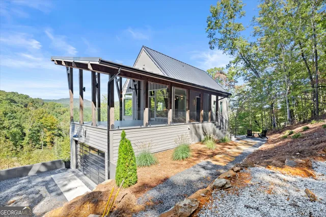 a view of a house with a porch next to a yard