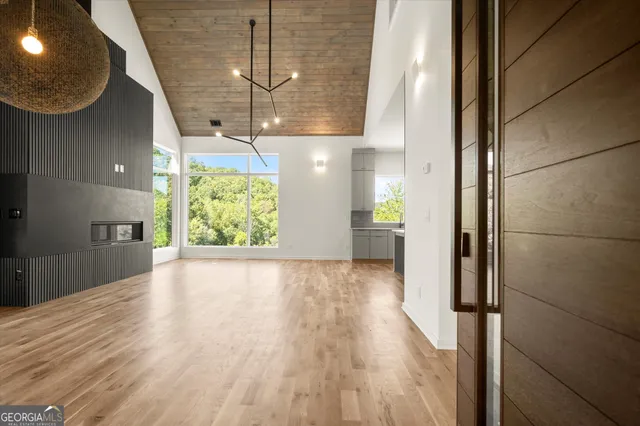a view of an empty room with a window and wooden floor