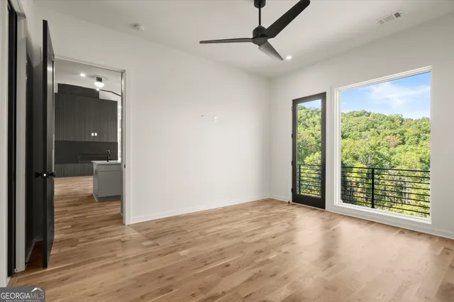 an empty room with a window and a ceiling fan
