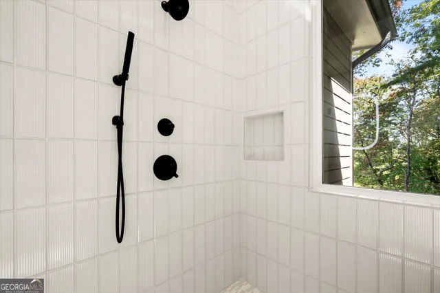 an empty room with wooden floor ceiling fan and windows