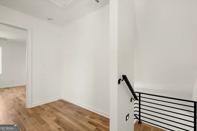 a view of an empty room with wooden floor