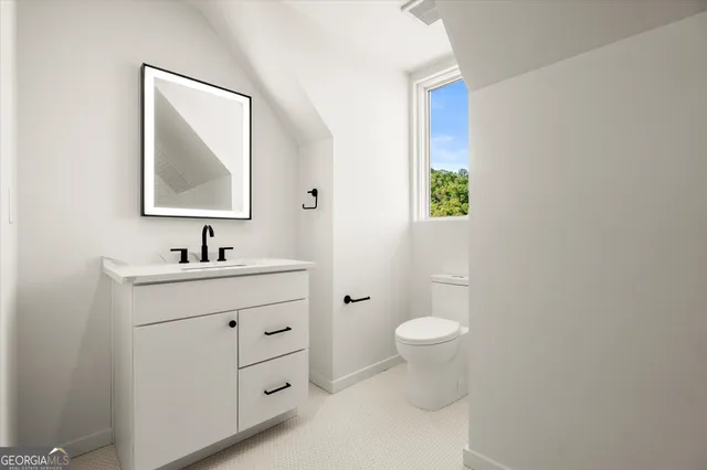 a bathroom with a toilet a sink a mirror and bathtub