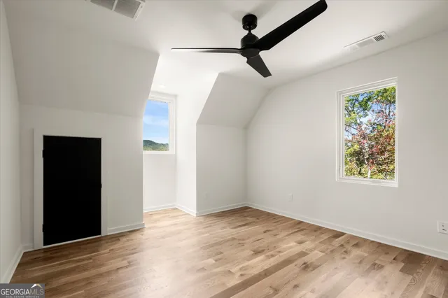 an empty room with closet and a ceiling fan