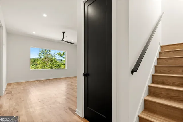 a view of hallway with a large window and wooden floor