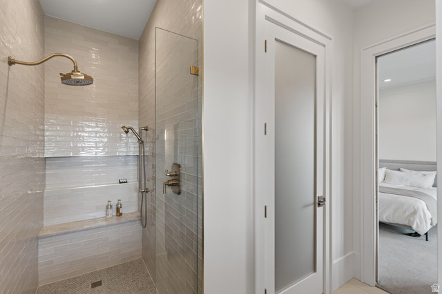 12308 Mariah Circle Draper, UT 84020 - Photo 197 of 293 Guest House Shower enclosure featuring a rain shower head, handheld shower fixture, built-in bench, and glass paneling