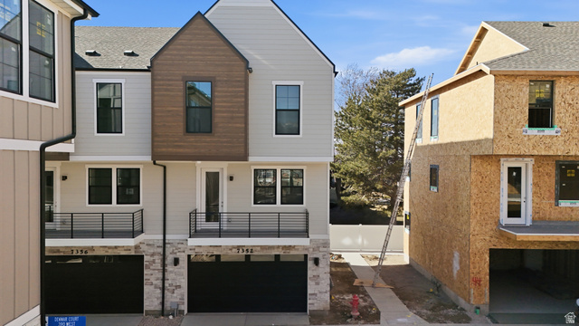 7338 South Seven Tree Lane, Unit 75 Midvale, UT 84047 - Photo 26 of 30 View of front facade featuring a balcony, a garage, and driveway