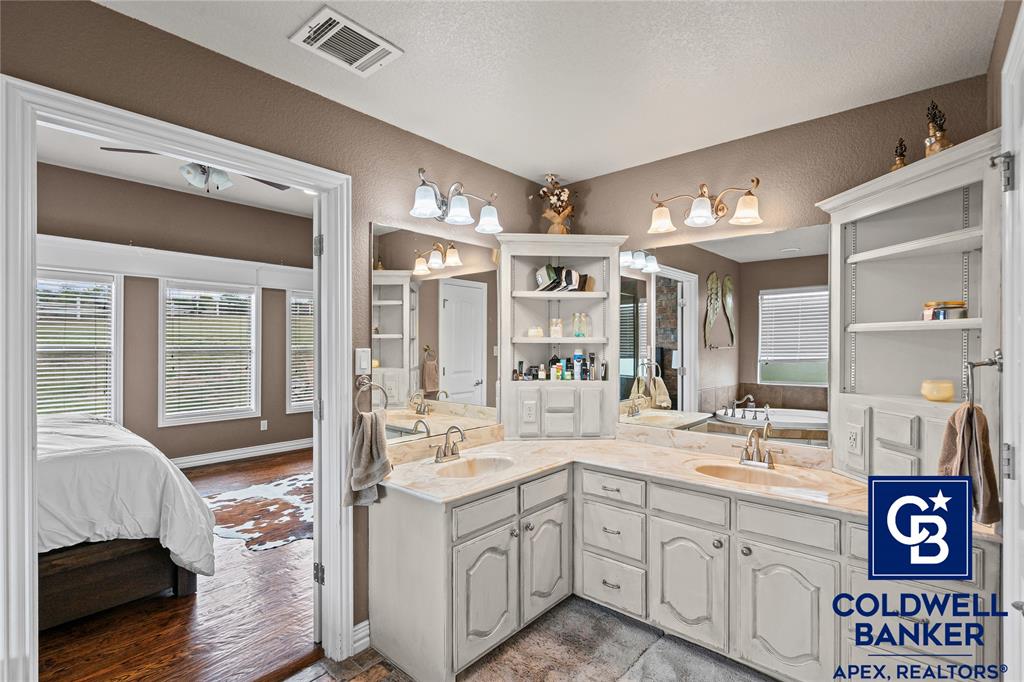 1316 Prairie Point Rhome, TX 76078 - Photo 16 of 30 a spacious en suite bathroom with a double vanity sink a mirror and a shower