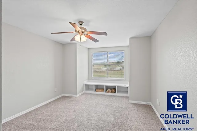 a view of a room with a ceiling fan and window