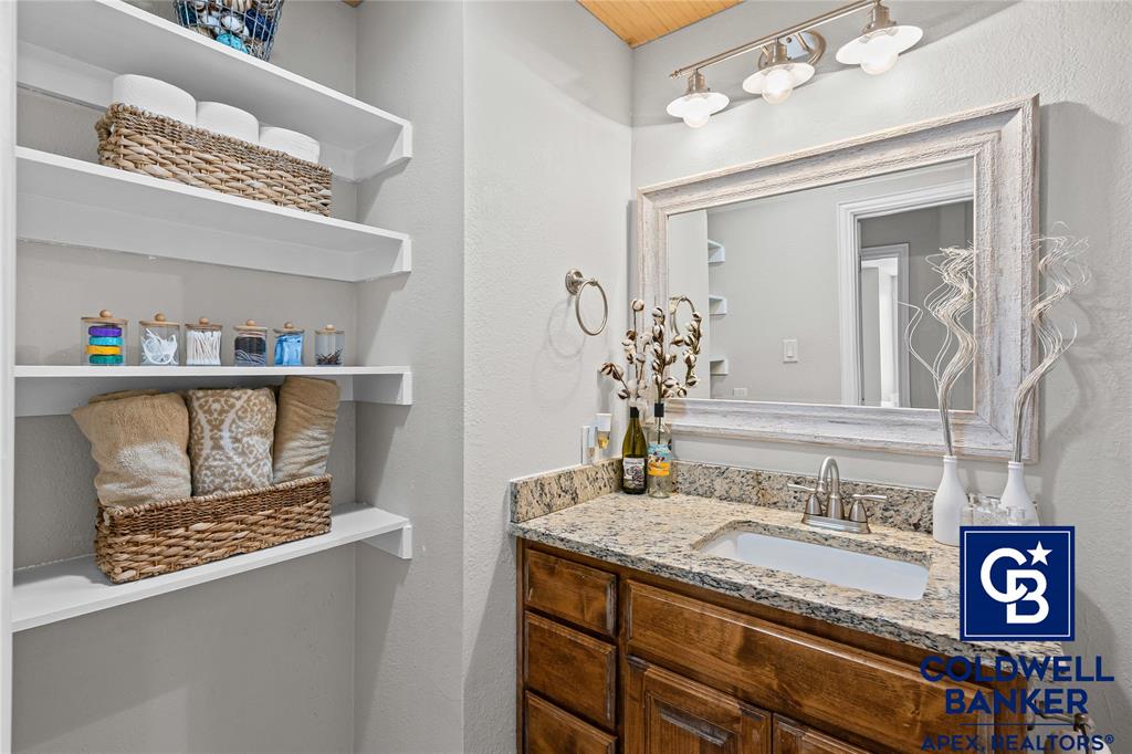 1316 Prairie Point Rhome, TX 76078 - Photo 22 of 30 a bathroom with a granite countertop sink and a mirror