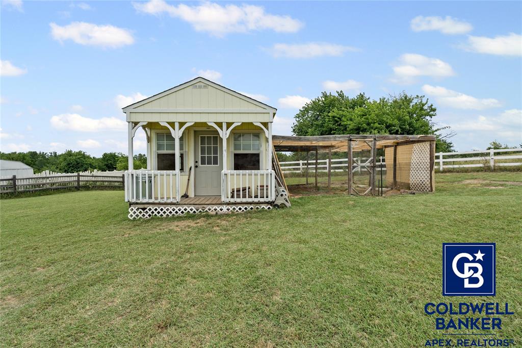 1316 Prairie Point Rhome, TX 76078 - Photo 27 of 30 a view of a wooden house with a big yard and potted plants