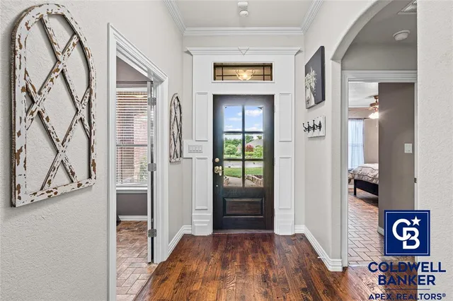 an entryway with a door and wooden floor