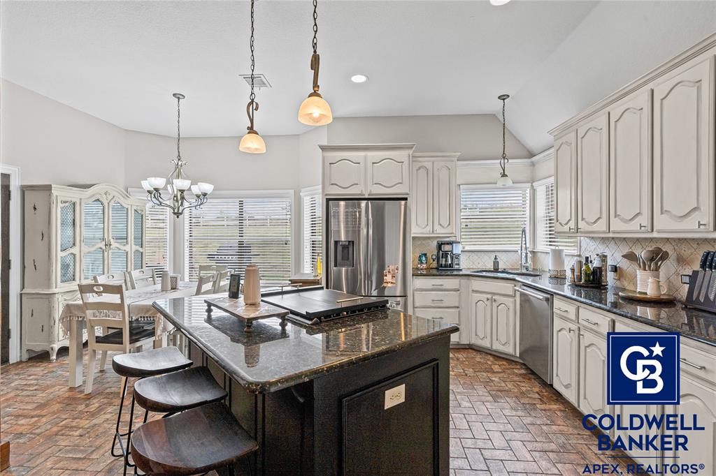 1316 Prairie Point Rhome, TX 76078 - Photo 8 of 30 a kitchen with granite countertop a sink a stove and cabinets