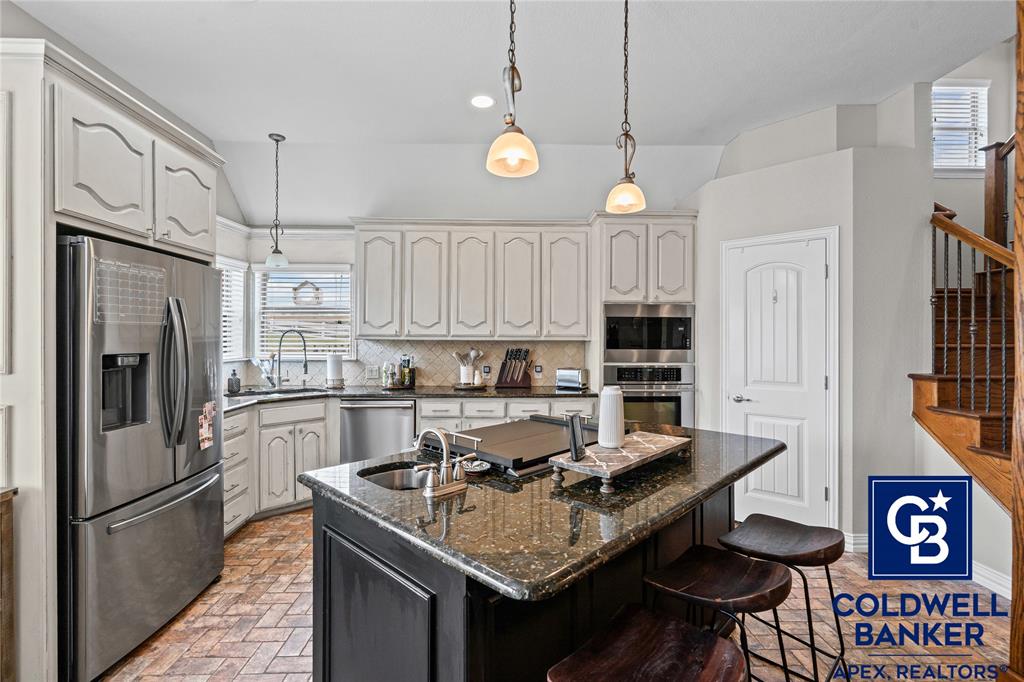 1316 Prairie Point Rhome, TX 76078 - Photo 10 of 30 a kitchen with stainless steel appliances granite countertop a sink refrigerator and cabinets