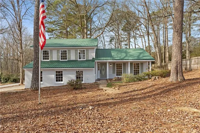 a view of a yard in front of a house with large tree