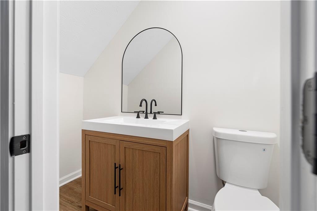 3905 Hunters Chase Southwest Conyers, GA 30094 - Photo 16 of 29 a bathroom with a toilet a sink and a mirror