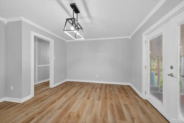 a view of empty room with wooden floor and ceiling fan