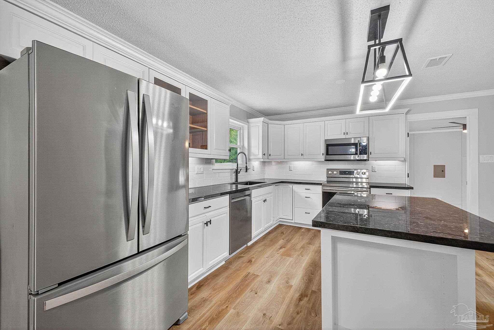 4673 Van Horn Road Milton, FL 32583 - Photo 15 of 48 a kitchen with stainless steel appliances granite countertop a refrigerator a stove and a sink with granite countertops