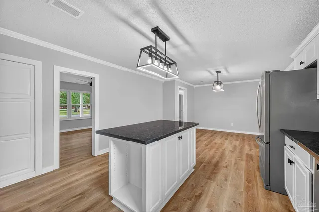 a kitchen that has a lot of cabinets and wooden floor