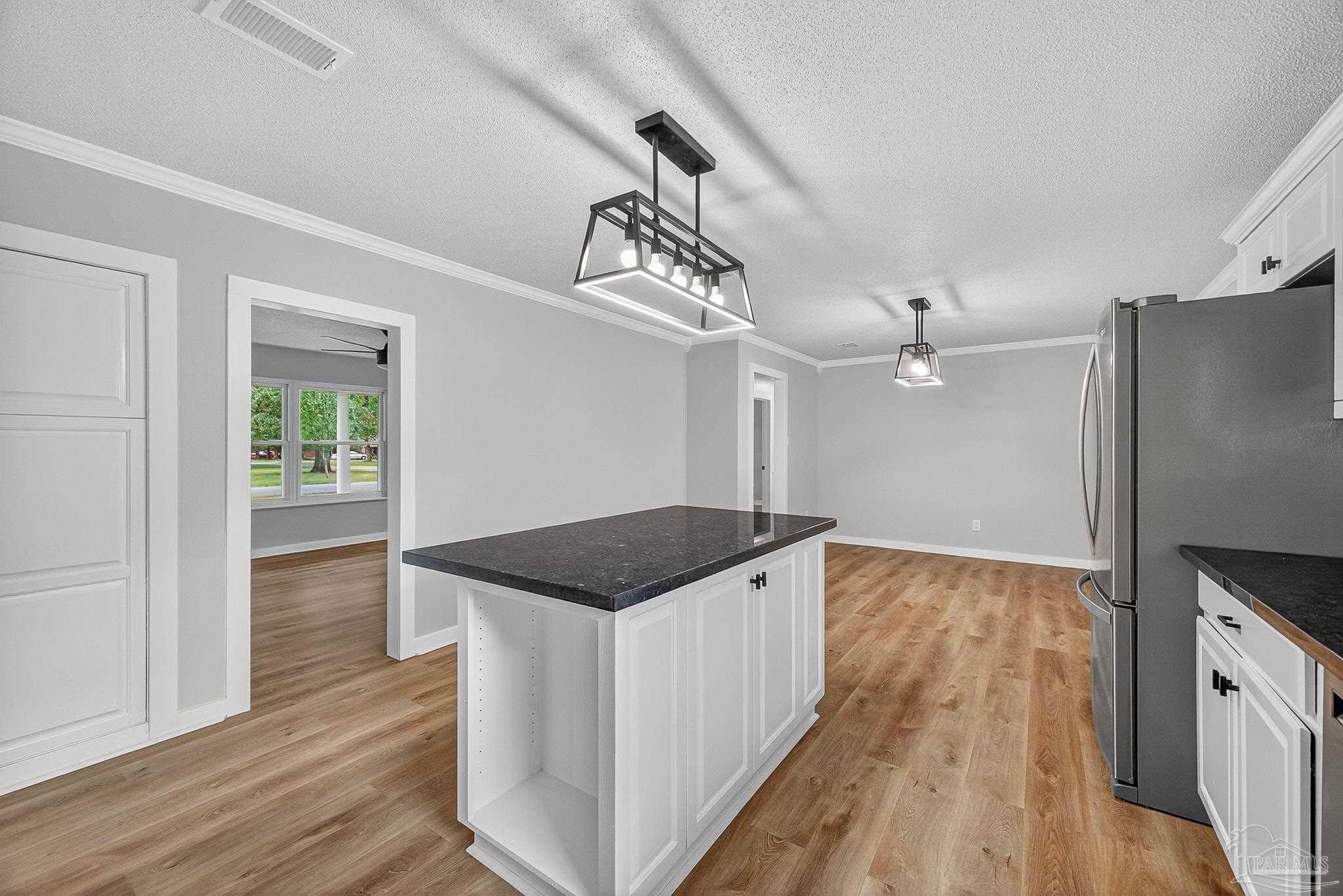 4673 Van Horn Road Milton, FL 32583 - Photo 17 of 48 a kitchen that has a lot of cabinets and wooden floor