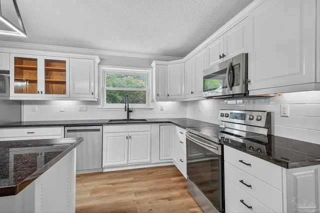 a kitchen with stainless steel appliances granite countertop a sink stove and cabinets