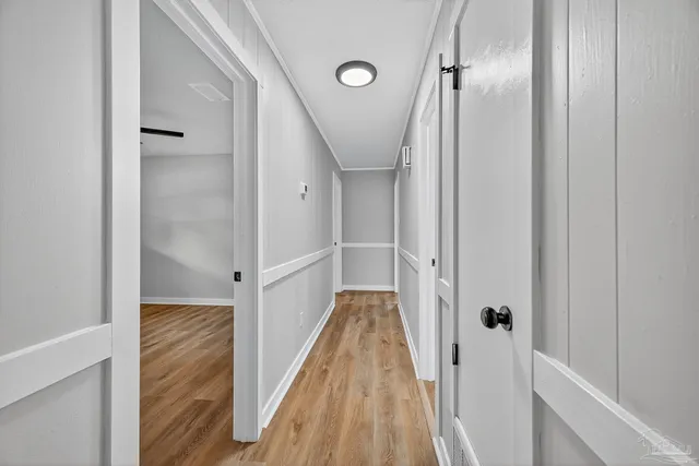 a view of a hallway with wooden floor and staircase