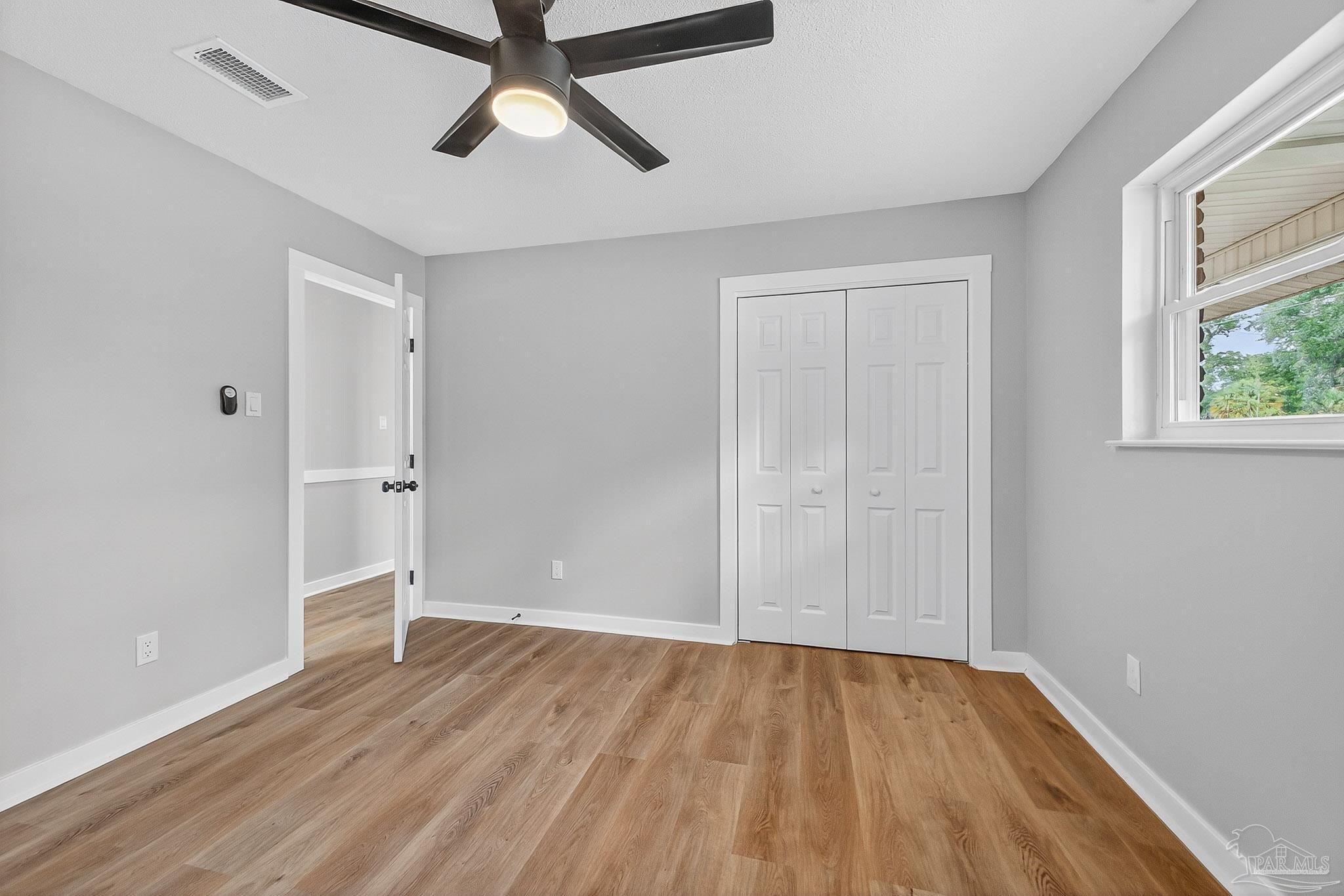 4673 Van Horn Road Milton, FL 32583 - Photo 28 of 48 an empty room with wooden floor cabinet and windows