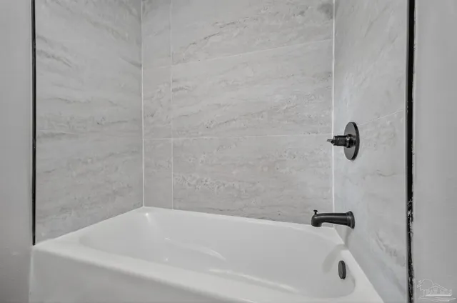 a white bath tub sitting next to a shower