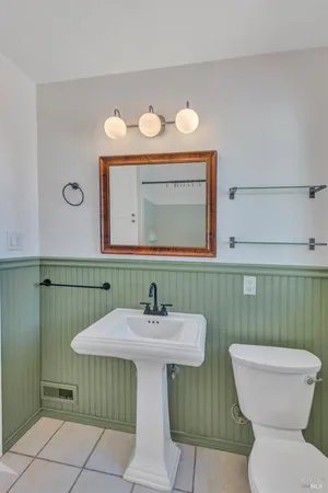 a bathroom with a sink mirror and toilet