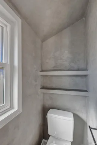 a toilet sitting next to a window