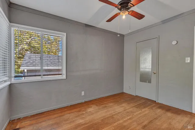 a view of a room with a ceiling fan and a window