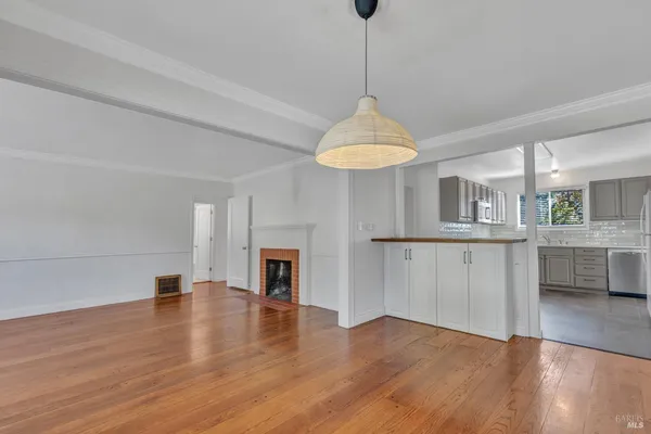a view of a room with wooden floor and a ceiling fan