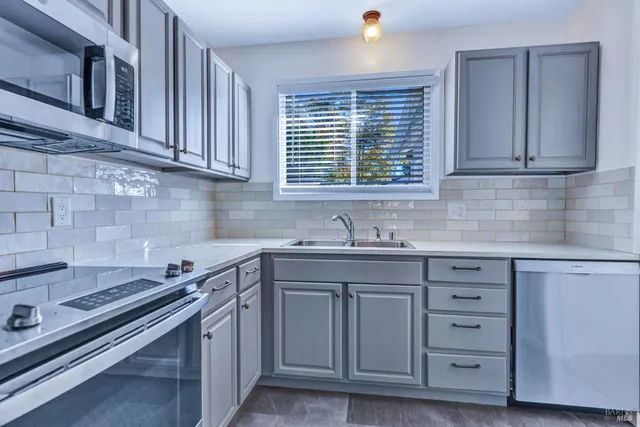a kitchen with cabinets appliances a sink and a window