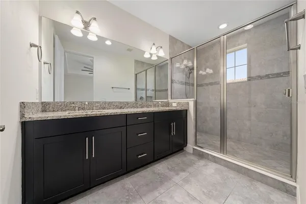 a bathroom with a granite countertop sink mirror and shower