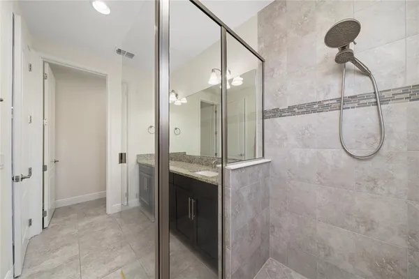 a bathroom with a granite countertop shower and a sink
