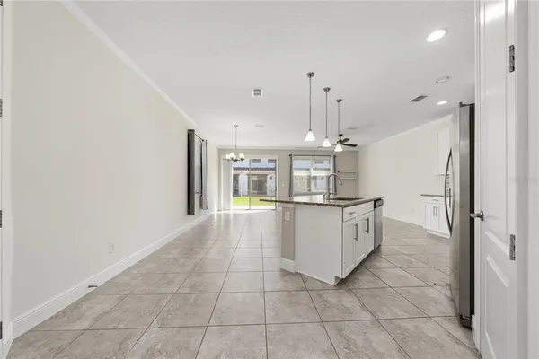 a large white kitchen with a sink and dishwasher a refrigerator with wooden floor