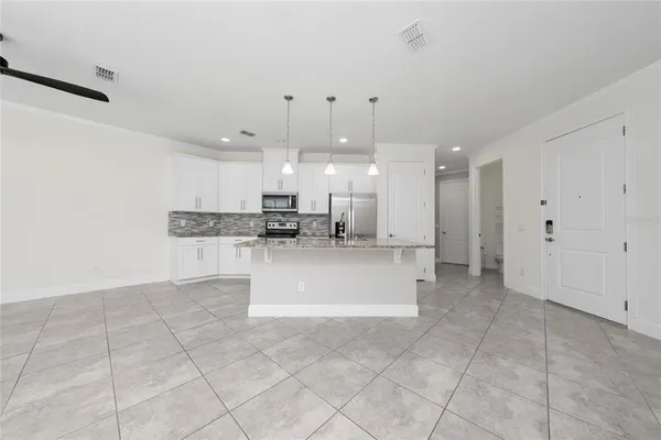 a view of kitchen with refrigerator sink and cabinets