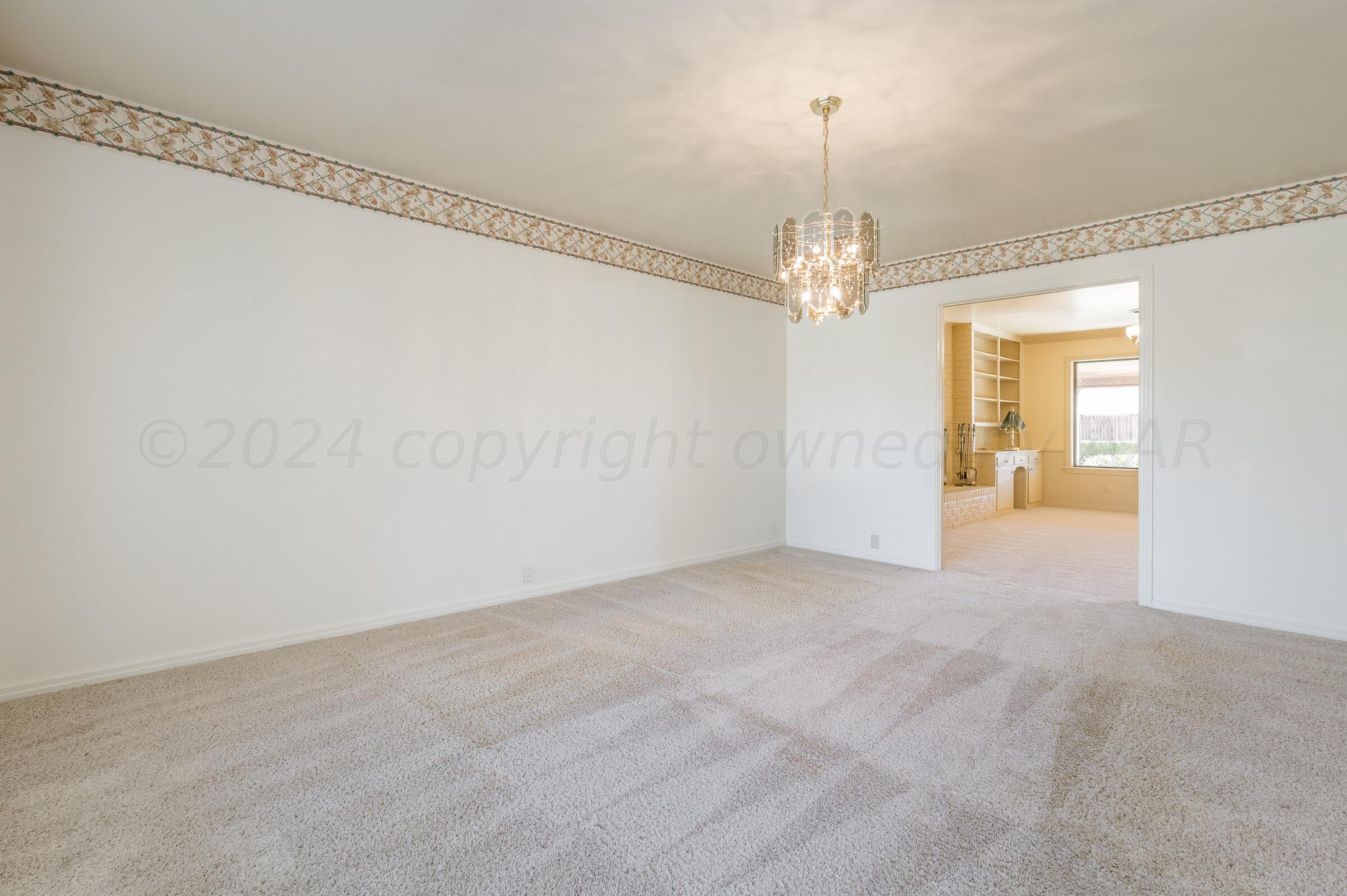 6113 Elmhurst Road Amarillo, TX 79106 - Photo 12 of 28 a view of a chandelier in big room and a chandelier fan