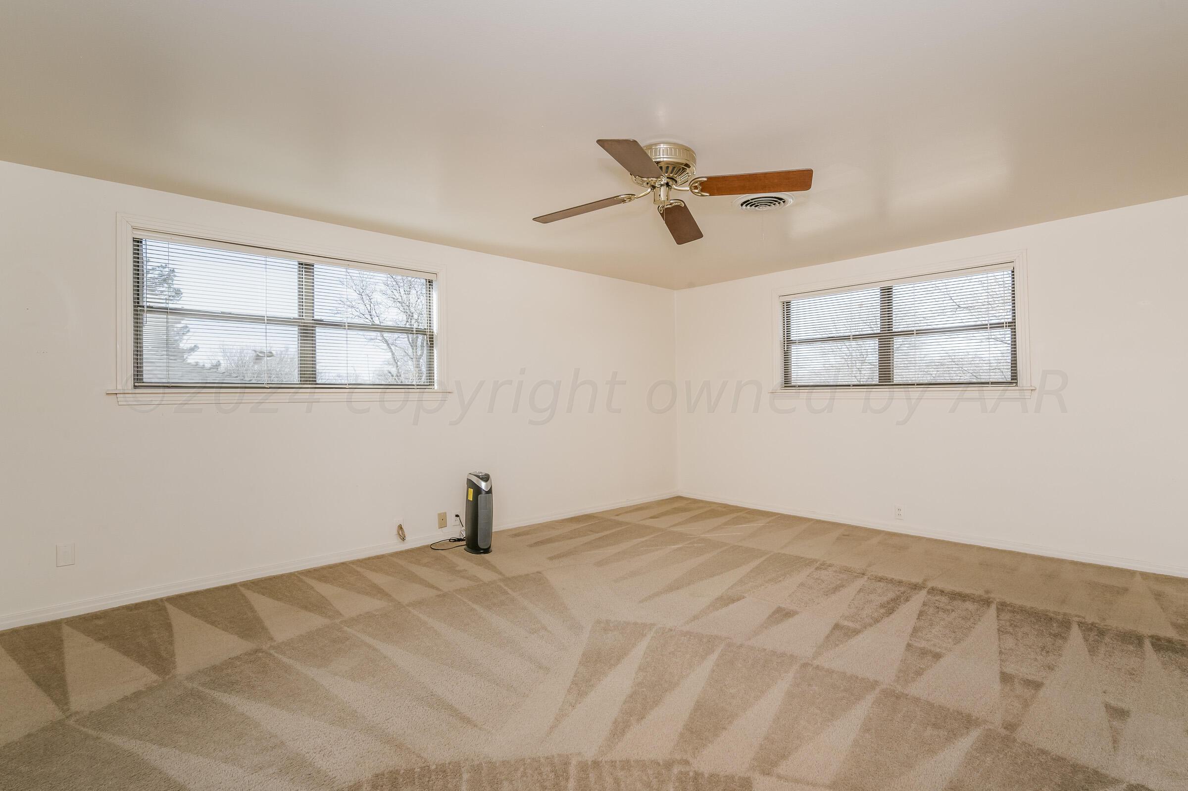 6113 Elmhurst Road Amarillo, TX 79106 - Photo 17 of 28 a view of a big room with wooden floor and windows