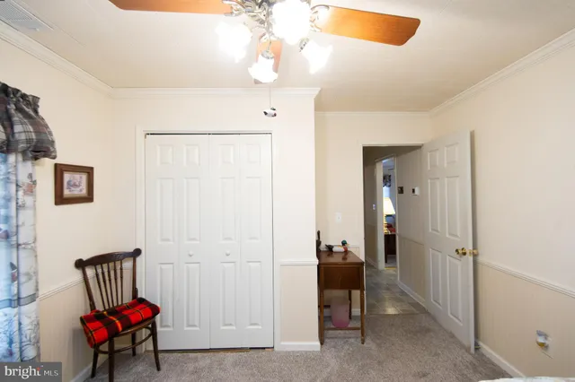 a bedroom with furniture and a chandelier fan