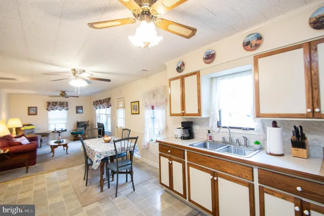 a kitchen with a dining table chairs sink and cabinets