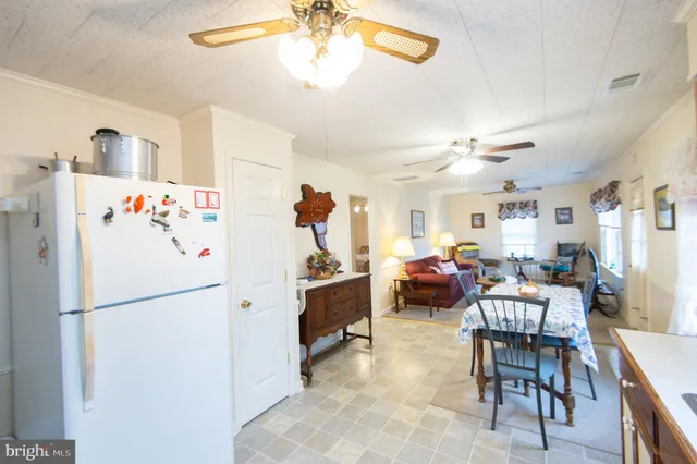 a living room with furniture a refrigerator and a dining table
