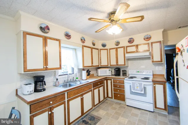 a kitchen with stainless steel appliances granite countertop a sink a stove and a refrigerator