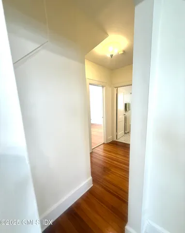 a view of a hallway with wooden floor