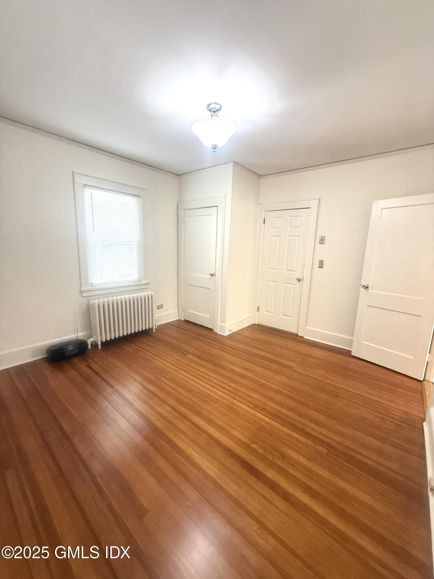 217 River Extension, Unit LOWER LEVEL Cos Cob, CT 06807 - Photo 12 of 16 an empty room with wooden floor and windows