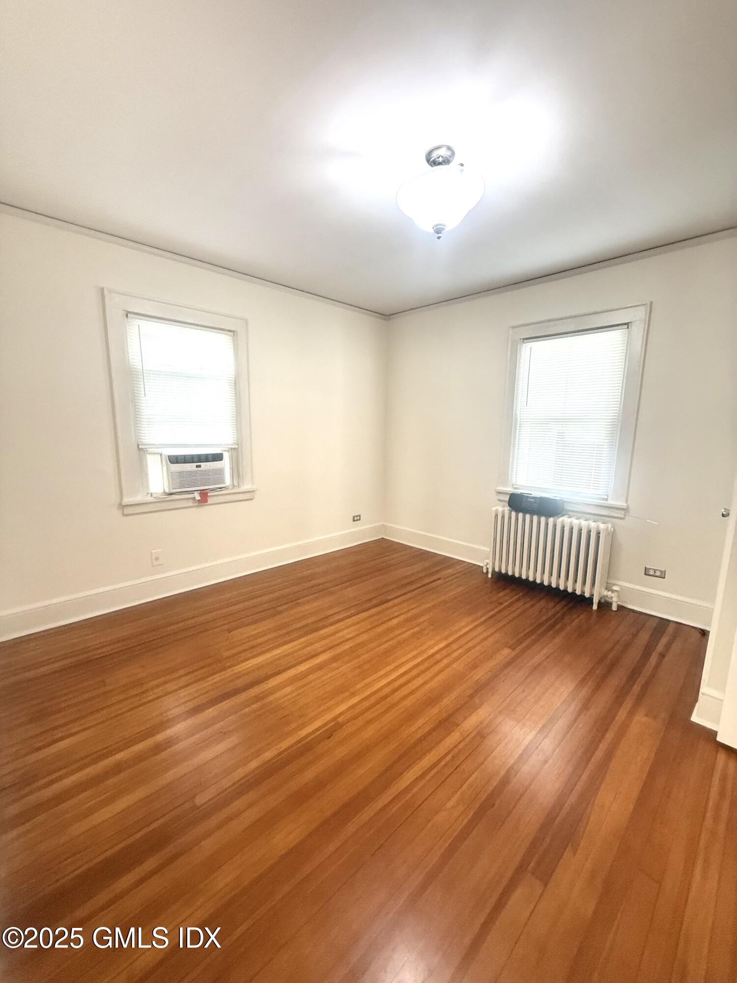 217 River Extension, Unit LOWER LEVEL Cos Cob, CT 06807 - Photo 13 of 16 an empty room with wooden floor and windows